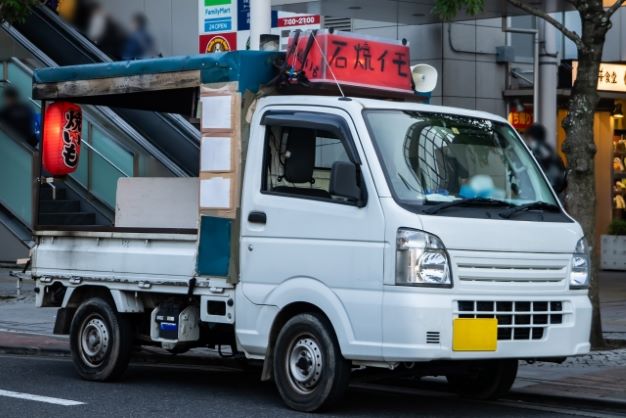 路上で営業する焼き芋の移動販売車