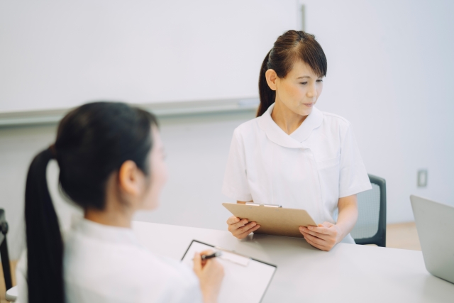 バインダーを手にした2人の女性の画像