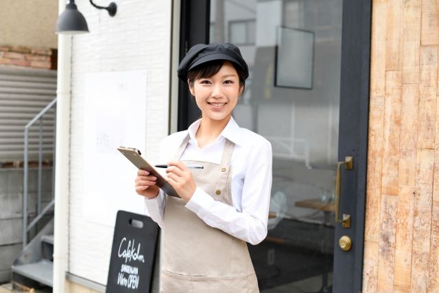 お店の前で注文を取る女性